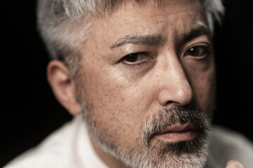 Obraz premium グレイヘアの髭のあるミドル男性の顔/スタジオ撮影黒背景