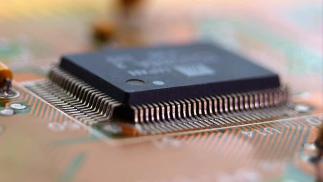 Macro video reveals the processor and transistors on a motherboard, displaying the precision of electronic components.