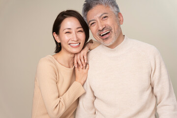 ミドル世代夫婦の笑顔のポートレート/男性の肩に寄りかか微笑む女性