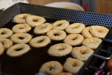 detail shot of the dough of a doughnut in a deep fryer with a lot of oil