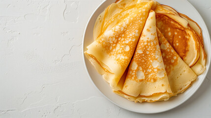 Plate of thin, golden crepes on a textured white background. Simple and minimalistic breakfast concept with space for text, perfect for food blogs and culinary websites.