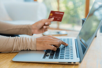 Close up credit card using for online payment, banking and shopping on the internet network with laptop computer showing credit card technology for online secured wallet top up and crucial purchase