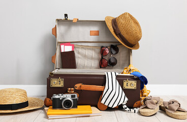 Clothes, camera and suitcase indoors. Prepare for travel