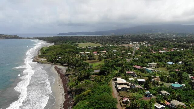 The lush pearls airport area in grenada with beach and waves, overcast sky, aerial view