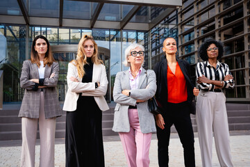 Team of multiracial and diverse businesswomen led by boss posing seriously for the camera.