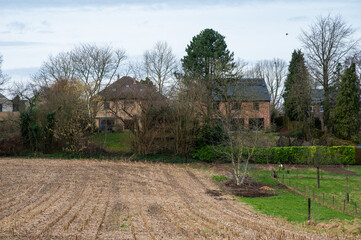 Harvested wheat fields and meadows with farmhouses around Herent, Brabant, Belgium