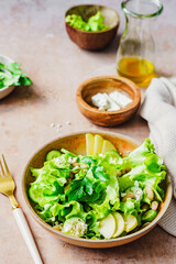 Frischer grüner Salat mit Bohnen und Fetakäse auf einem beigen Tisch. Diät, gesunde Ernährung.
