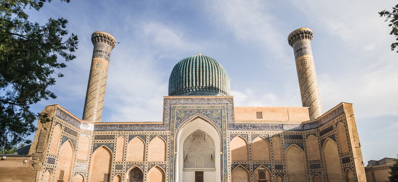 Facade of the Gur Emir mausoleum with mosaic brick walls in the ancient city of Samarkand in Uzbekistan, oriental architecture
