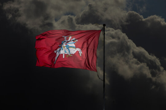 Historical Lithuanian flag waving in the wind against cloudy sky