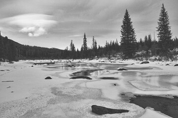 Icy river in a winter wonderland under a cloudy sky