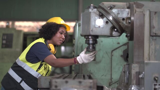 African American tired worker woman hard working sweat dirty gloves repair old machine in industrial manufacturing factory. black female labor mechanic engineer maintenance and check. hot weather