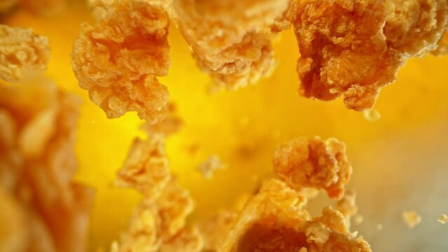 Super Slow Motion of Flying Fried Chicken Pieces on Golden Background. Filmed on High Speed Cinema Camera, 1000fps.