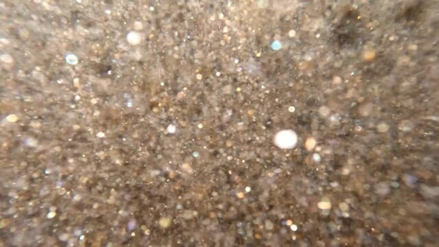 Underwater sea abstract background sparkling gold mica sand glittering