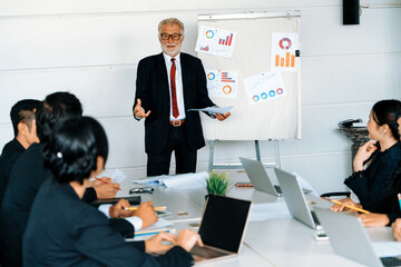 Senior leader speaker speaks to public people audience in training workshop or conference. Mature...