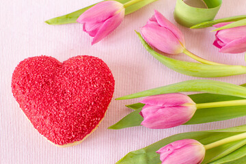 Heart shaped donut with pink glaze on white plate for festive background or Valentine day, Mother day, Birthday celebration