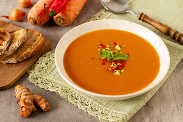 Healthy  spicy vegetarian soup with carrot, onion, tomato, red pepper and turmeric
