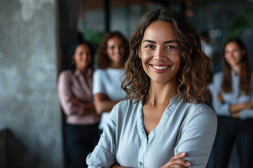 Smiling successful Businesswoman with crossed arms and diverse team in background in office setting