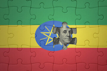 puzzle with the national flag of ethiopia and usa dollar banknote. finance concept