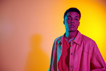 young african american man posing in trendy and casual clothing with vibrant gradient background