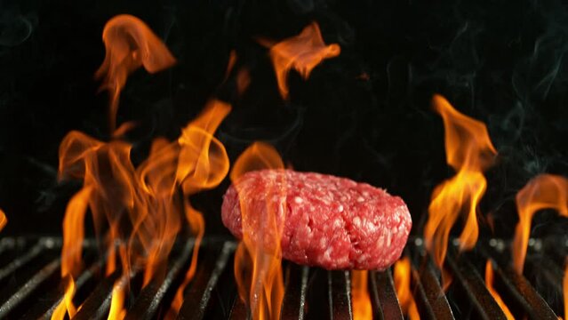 Super Slow Motion of Raw Hamburger Pieces Falling on Grill With Fire. Filmed on High Speed Cinema Camera, 1000 fps, Camera Placed on High Speed Cine Bot, Following the Target.