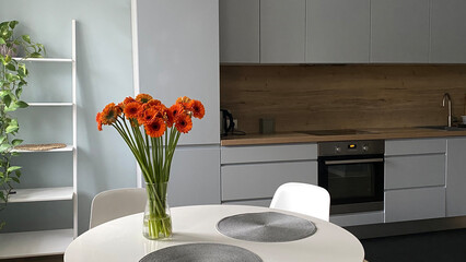 White dinning table in front of scandinavian kitchen, elegant nordic design and interior decor