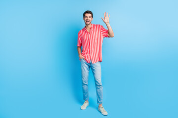 Full body photo of positive guy wear stylish shirt jeans trousers waving palm say hi arm in pocket...
