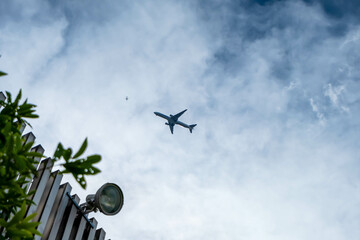 屋上から見上げた空に飛ぶ飛行機