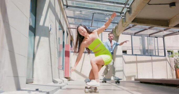Happy couple playing skateboard enjoy in the outdoor.