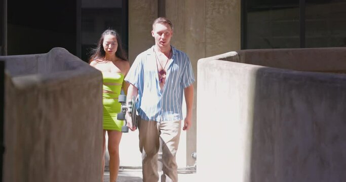Couple playing skateboard together outdoor.