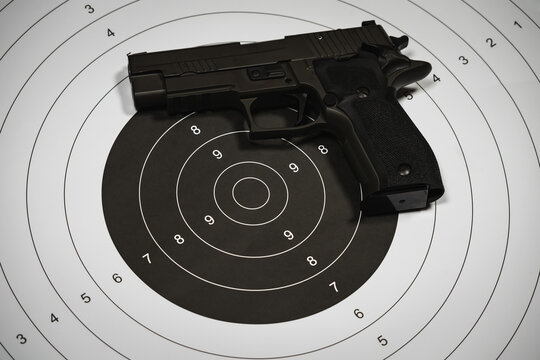 Classic shooting target and 9-mi pistol, close-up photo.