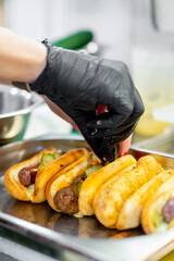 Chef hand cooking set hot dog on kitchen