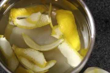 Fotobehang Lemon skin in pan with water. Directly above. © ffolas