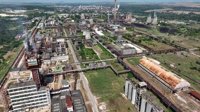 Aerial view of chemical plant. Drone shot. Billowing steam from smoke stack filling sky. Smoking chimneys from factory. Chimneys of big oil refinery polluting environment.