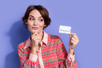 Photo of minded smart positive woman with bob hairstyle dressed print shirt looking at debit card...