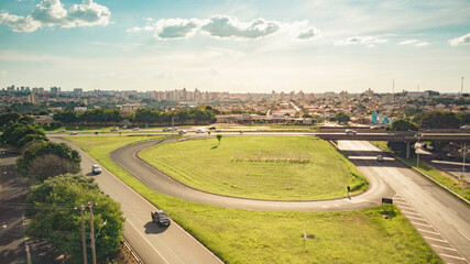 Aerial drone view of the entrance to the city of Sao Jose do Rio Preto with the sign in the foreground, the highway viaduct and the city center buildings in the background on a sunny day