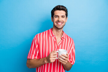 Portrait of positive cheerful guy with stubble wear stylish shirt holding cup of latte at coffee...