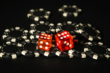 Dice and chips from winnings on the craps black table in the club. Fortune in the game depends on a...