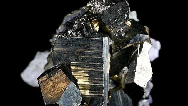 Iron Pyrite (fool's gold) cubic crystals and quartz rotating against a black background