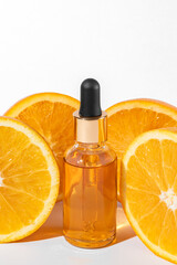 Vibrant composition with fresh oranges and serum dropper bottle with natural vitamin C for skincare. Beauty treatment, cosmetics mockup.