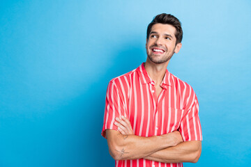 Photo of funky dreamy guy wear red shirt arms folded looking empty space isolated blue color...