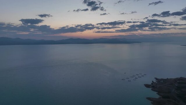 Scenic sunset or sunrise over Sevan lake popular holiday destination in Armenia, Caucasus, West Asia. Daytime Timelapse of moving white, grey clouds over lake Sevan on background hills