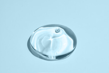 Glycerin gel texture. Transparent serum drop on blue background. Liquid gel moisturizer with bubbles macro