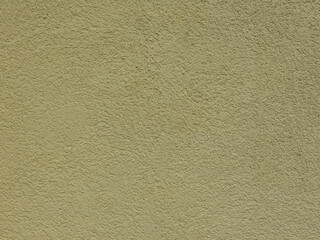 Textured plaster on a wall in the color yellow, texture