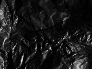 Black wrinkled glossy paper texture. Luxury background. Black stone