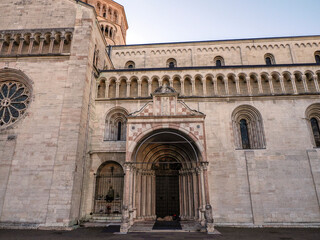 Fototapeta na wymiar Homeless tramp sleeping outside entrance of the Medieval Cathedral of San Vigilio in Trento , Italy