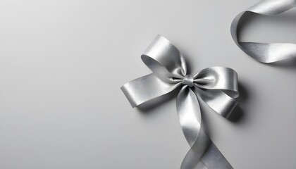 Silver curled ribbon with shimmer on light gray background from above