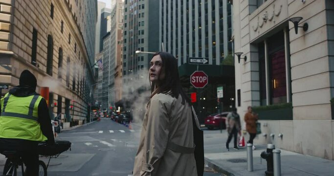 Moody cinematic portrait of attractive female looking around in urban dynamic New York City surroundings