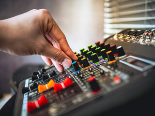 Close-up of sound engineer hands adjusting control sound mixer in recording, broadcasting...