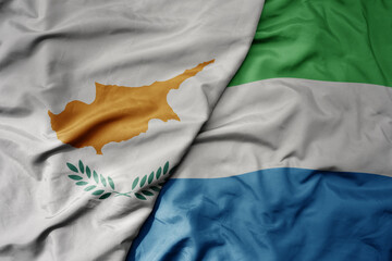 big waving national colorful flag of sierra leone and national flag of cyprus.
