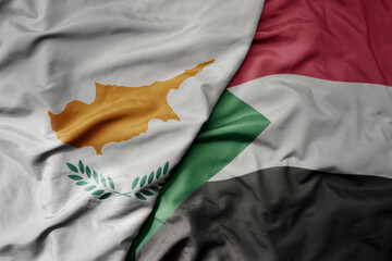 big waving national colorful flag of sudan and national flag of cyprus.